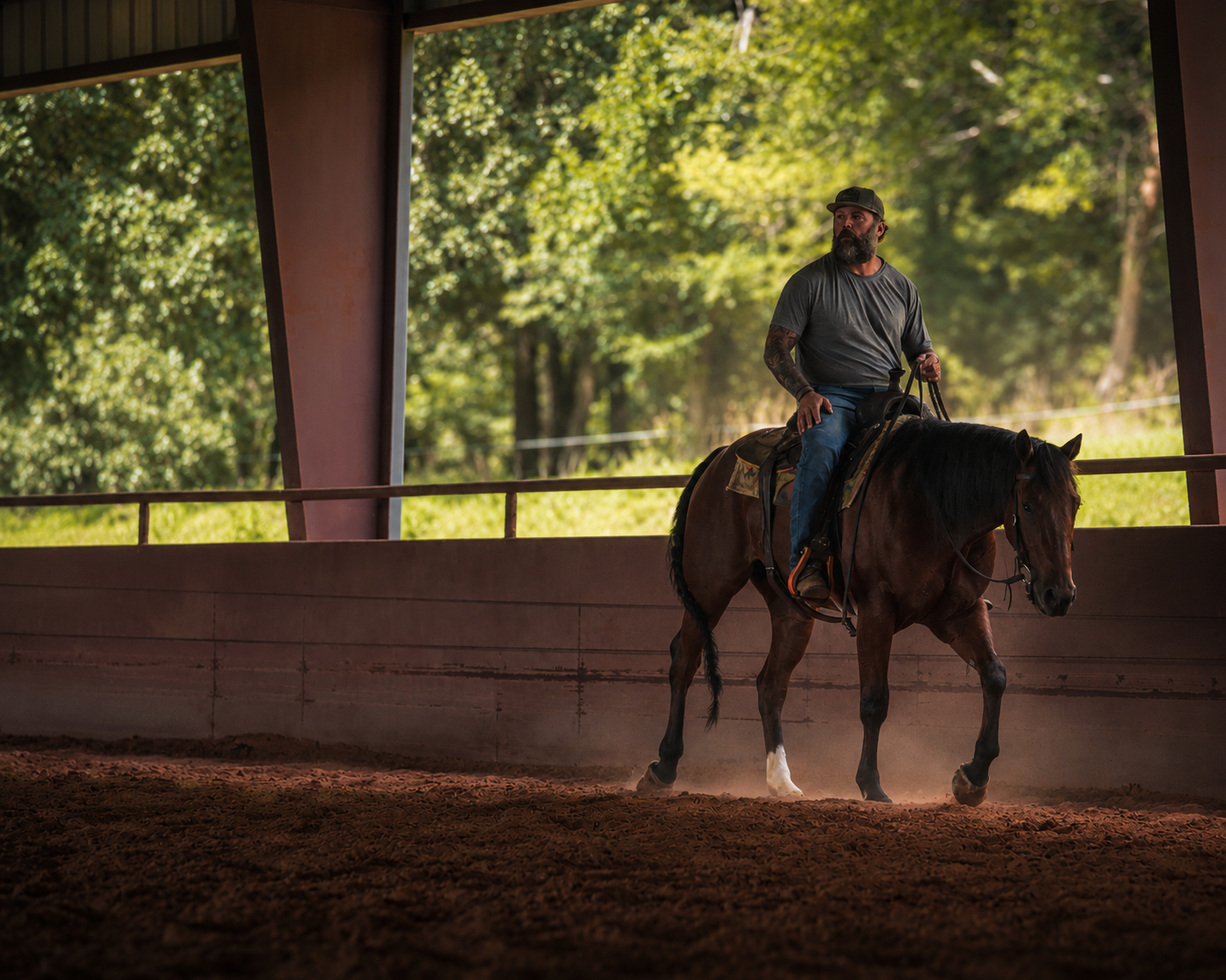 Derek riding a horse in the covered arena